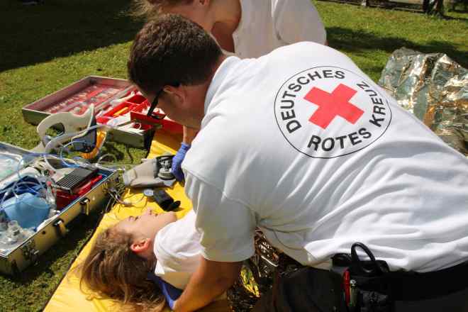 Helfer des Bayerischen Roten Kreuzes versorgen eine verletzte Person.